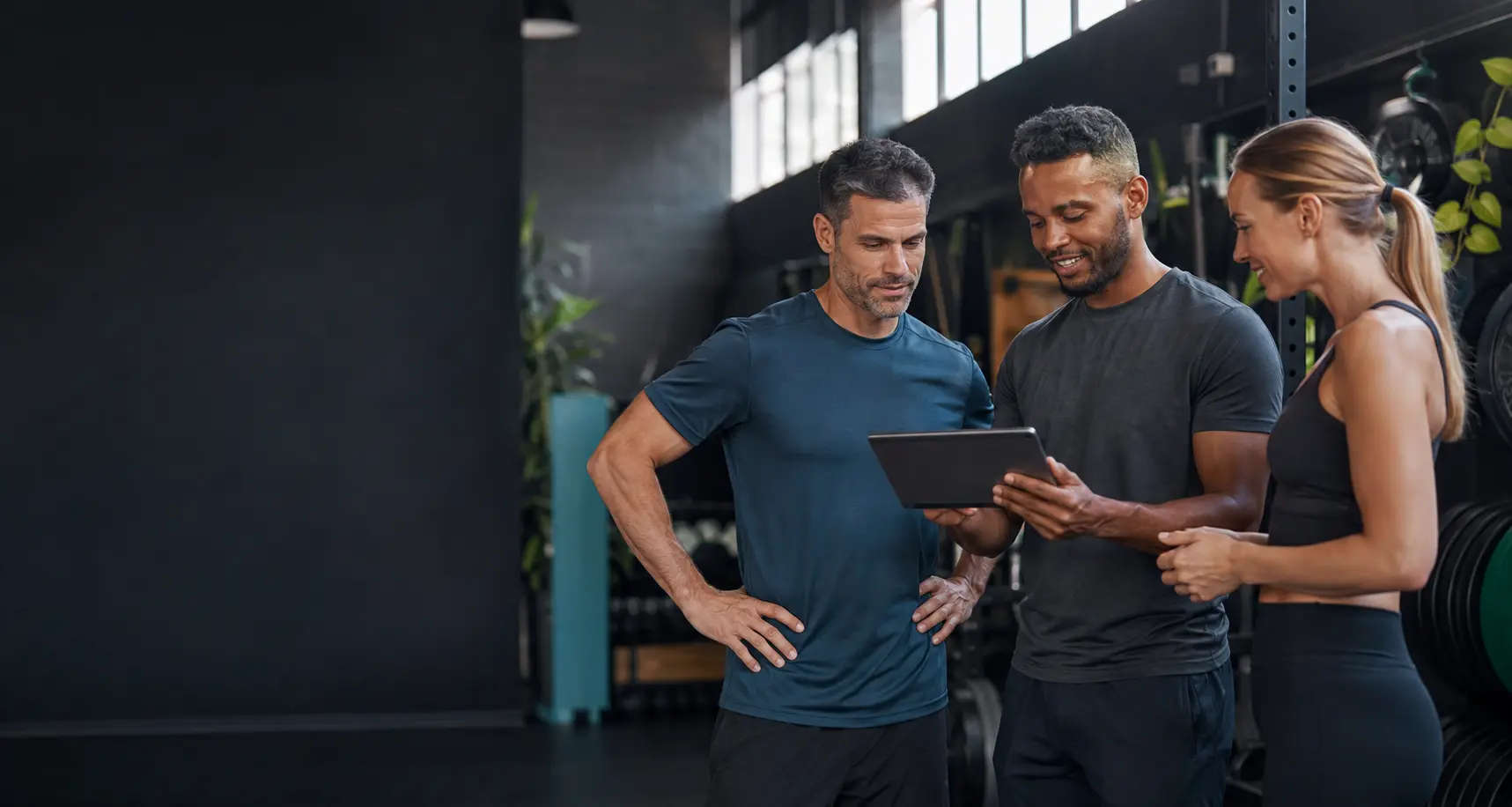 Trainers and a client reviewing a plan together in a training studio